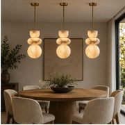 Three Alverra pendants above a round dining table