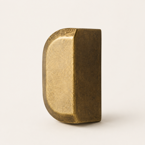 Antique bronze drawer pull on a clean warm white background