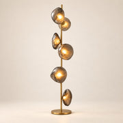 Auralis Glass Floor Lamp in Gold and Smoky Grey on a warm ivory background
