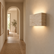Lumo natural stone wall light illuminating a warm hallway