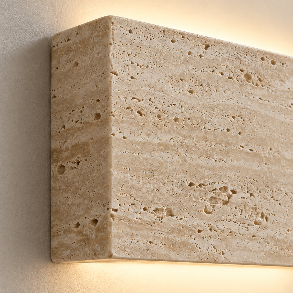 Close-up of the Lumo wall light's porous natural travertine