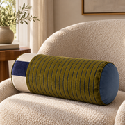 Sovana Olive Navy velvet neck-roll pillow on a cream armchair