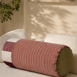 Sovana velvet neck-roll pillow in Rose Plum styled on a sofa